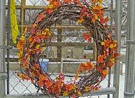 Children help decorate a wreath made of natural materials as they learn about each season of the year